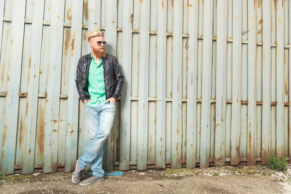 Jonge, bebaarde man naast ijzeren hek — Stockfoto