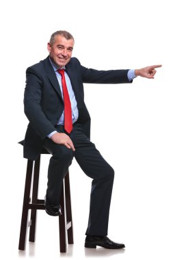 iş adamı oturur ve uzağa işaret