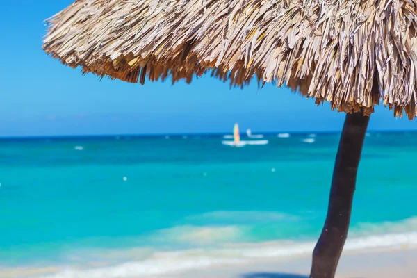 Nahaufnahme mit Strohschirm an einem wunderschönen tropischen Strand — Stockfoto