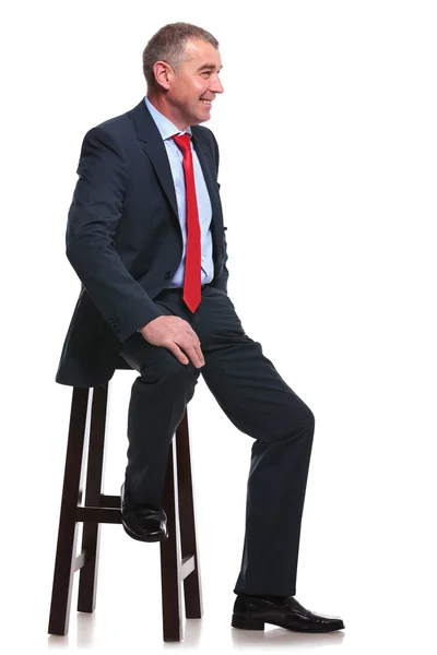 Üzleti ember ül és mosolyog — Stock Fotó