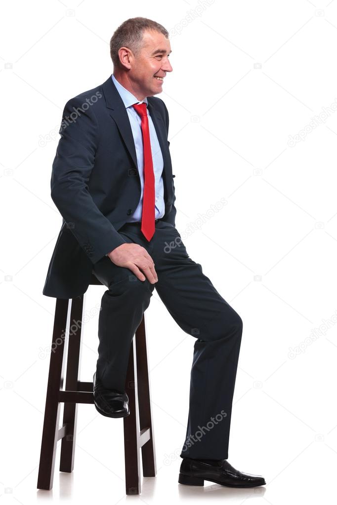 business man sits and smiles