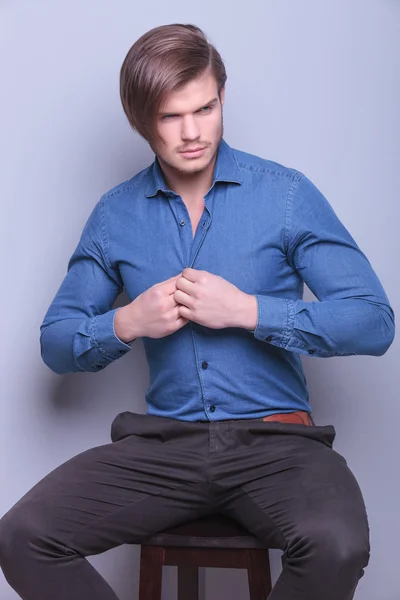 Man looking to side while opening his shirt — Stock Photo, Image