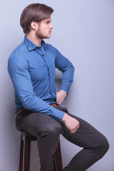 Seitenansicht eines jungen Modemachers im Sitzen — Stockfoto