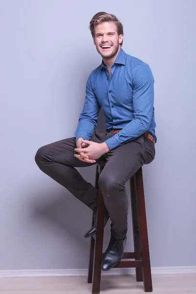 Laughing young casual man sitting — Stock Photo, Image