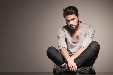 yoga konumda ciddi sakallı moda adam oturur