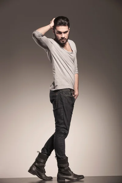 Young man fixing his hair in a fashion pose — Stock Photo, Image