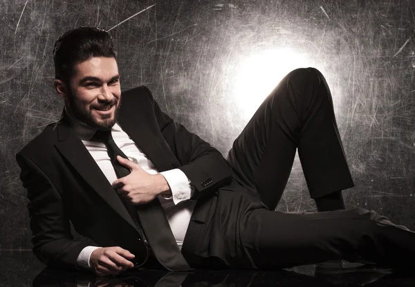 Business man in suit holding his tie and smile — Stock Photo, Image