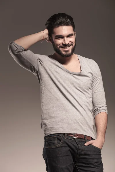 Joven sonriente arreglando su cabello — Foto de Stock