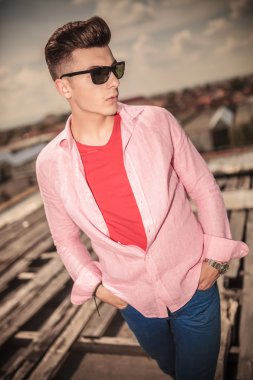 güneş gözlüğü ve elleri ceplerinde moda genç casual adam