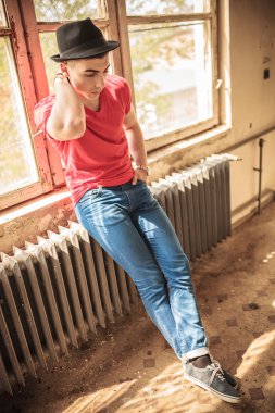 şapkalı yaşlı bir ısıtıcı üzerinde oturan üzgün bir adam 