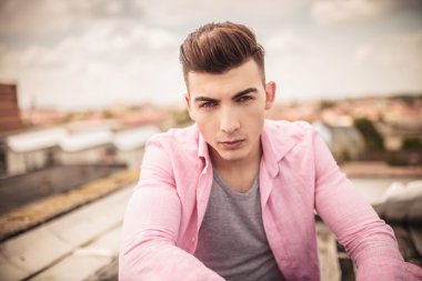 pembe tişörtlü adam kameraya bakıyor