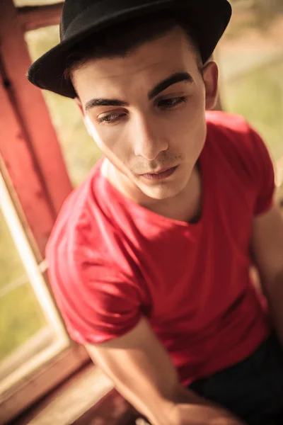 Sad casual young man near old window — Stock Photo, Image