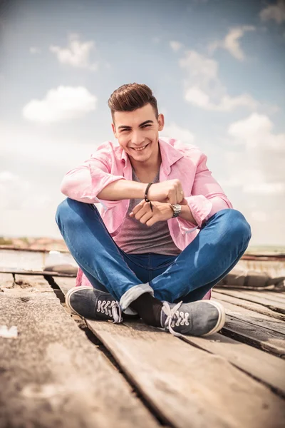 Jonge man zittend op de vloer lachen — Stockfoto