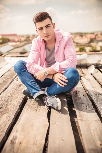 Sorrindo homem casual em posição de lótus sentado — Fotografia de Stock