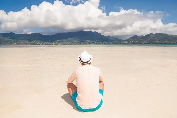 Genç bir adam sahilde oturan arkası — Stok fotoğraf
