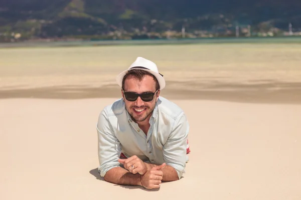 Mutlu genç casual adam beyaz kum plaj yatan — Stok fotoğraf