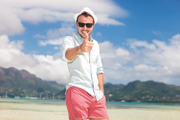 Uomo sorridente sulla spiaggia facendo il segno ok — Foto Stock