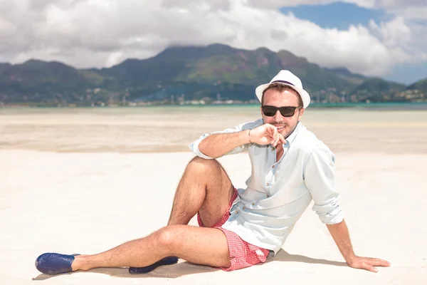 해변에 앉아 생각에 잠겨있는 젊은 남자 — 스톡 사진