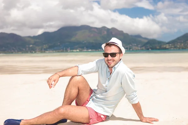 Glad ung casual man vila på stranden — Stockfoto