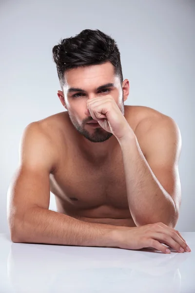 Seated naked man with hand covering his face — Stock Photo, Image