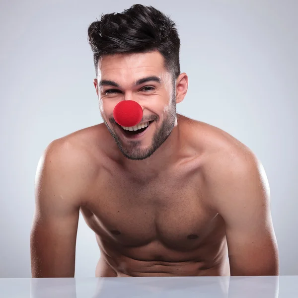 Hombre desnudo con nariz de payaso rojo riendo — Foto de Stock