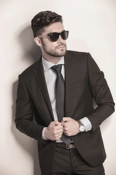 Sexy uomo d'affari con gli occhiali da sole tenendo il suo vestito — Foto Stock