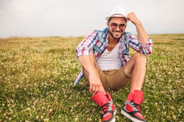 Şapkasını elinde tutan genç adam gülüyor