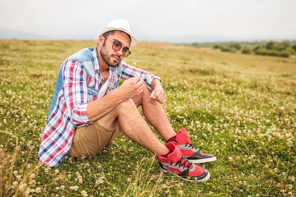 Hombre sosteniendo y mirando una flor — Foto de Stock