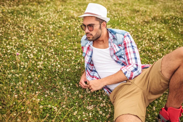 Mannen liggande på ett fält och tänker — Stockfoto