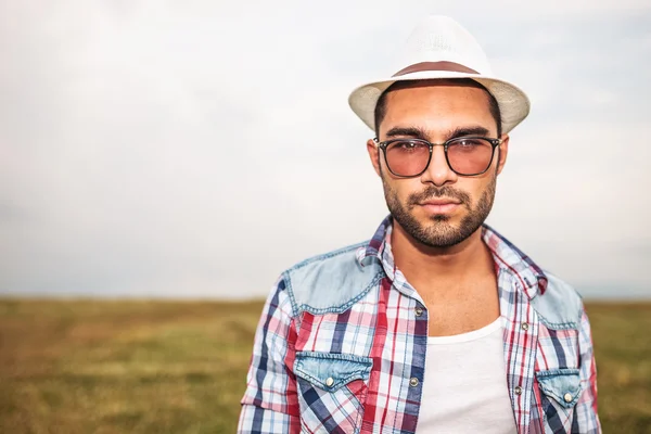 Jeune homme décontracté portant chapeau et lunettes — Photo