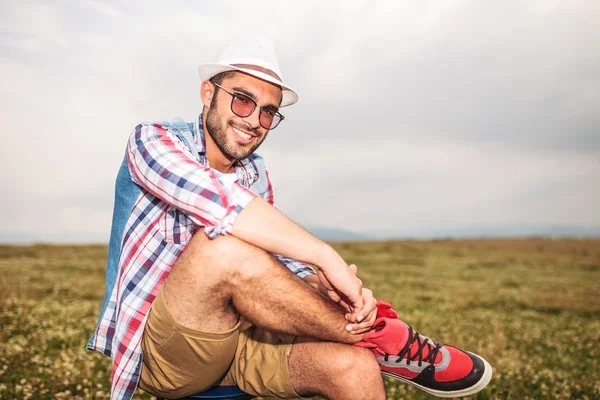 Расслабленный случайный человек, сидящий на стуле в поле — стоковое фото