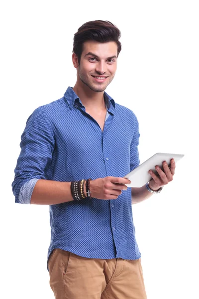 Jonge lachende casual man met een tablet van het stootkussen — Stockfoto