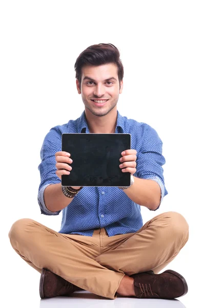 Sorrindo sentado homem mostrando a tela de seu tablet — Fotografia de Stock