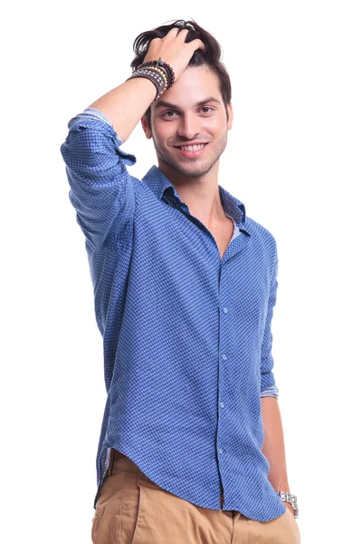 Relaxado jovem passando a mão através de seu cabelo — Fotografia de Stock