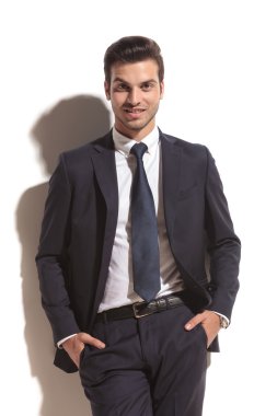 elleri cebinde gülümseyen iş adamı