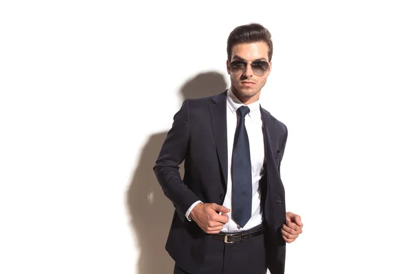 Sexy young business man with sunglasses opening his coat — Stock Photo, Image