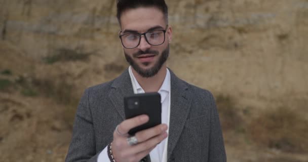 Vonzó Fiatalember Kint Áll Természetben Szemüveget Kabátot Visel Telefonokat Tart — Stock videók