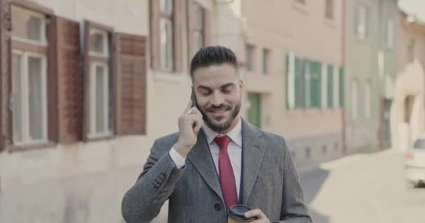 Привлекательный Бизнесмен Наслаждается Ходьбой Разговаривает Телефону Поднимает Чашку Кофе — стоковое видео