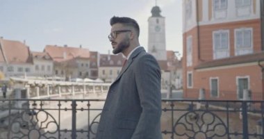 Çekici bir iş adamının yürüdüğünü, gözlük taktığını, arkasına baktığını ve arkasını döndüğünü gördüm.