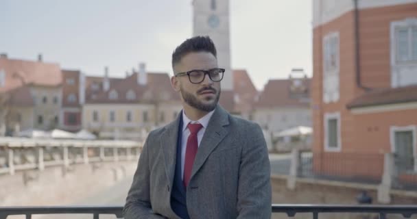 Σέξι Γενειοφόρος Άνδρας Φορώντας Μακρύ Παλτό Και Γυαλιά Κοιτάζοντας Γύρω — Αρχείο Βίντεο