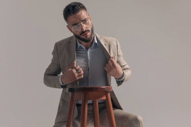 Yakışıklı iş adamı ceketini ayarlıyor, gözlük takıyor ve modaya ayak uyduruyor.