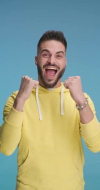 Yakışıklı sıradan bir adam başarıyı kutluyor, alkışlıyor, ellerini çırpıyor ve işaret ediyor.