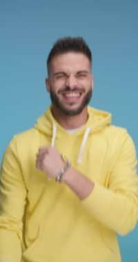 Sıradan bir adam kolunu kıvırıyor, zıplıyor ve dans ediyor, başarıyı kutluyor ve kamerayı işaret ediyor.