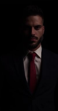 Zarif takım elbiseli dramatik traşsız adam. Ceketini düzeltip düzeltiyor. Tarafını arıyor ve karanlıkta uzaklaşıyor.