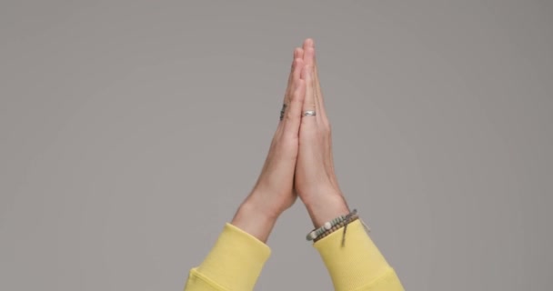 Руки Молодого Чоловіка Браслетами Повітрі Святкування Перемоги Перед Сірим Фоном — стокове відео