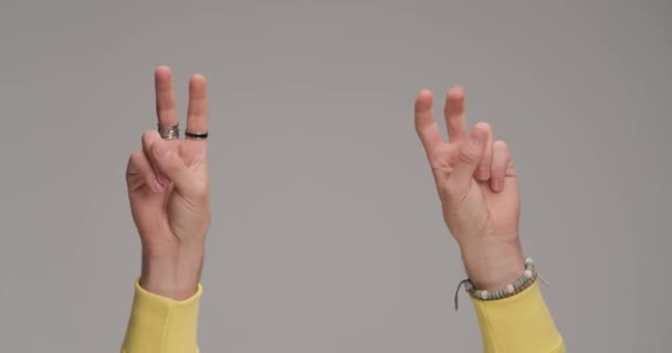 Мужские Руки Держат Пальцы Воздухе Делают Мирный Жест Перед Серым — стоковое видео