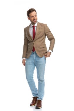 attractive businessman posing against white background, sticking one hand in pocket and smiling