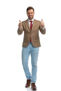 young businessman smiling at the camera and giving a thumbs up with both hands  against white background