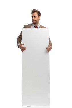 handsome businessman holding his vertical board and looking to the side against white background