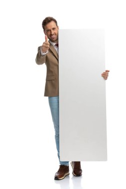 handsome businessman giving a thumbs up and holding his vertical board against white background